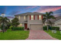 Charming two-story home with red shutters, a brick driveway, and a well-manicured lawn at 3941 River Bank Way, Punta Gorda, FL 33980