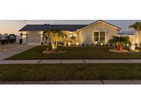 Charming home with a well-maintained front yard, featuring a lush lawn and landscaping, at dusk at 6286 Coniston St, Port Charlotte, FL 33981