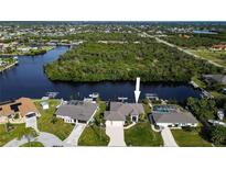 Waterfront home with lush landscaping, boat docks, and tranquil water views from above at 19246 Moore Haven Ct, Port Charlotte, FL 33948