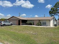 Charming single-story home with a well-manicured lawn and attached two-car garage at 23269 Lehigh Ave, Port Charlotte, FL 33954