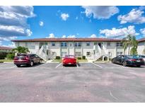 Attractive condo building featuring multiple units, stairs to the second floor, and ample parking spaces at 25100 Sandhill Blvd # F-203, Punta Gorda, FL 33983