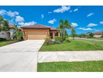 Charming single-story home with a well-manicured lawn, inviting landscape, and attached two car garage at 253 Marcheno Way, Nokomis, FL 34275