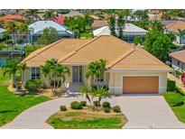 Well-maintained home showcasing a beautiful driveway, lush landscaping, and a warm, inviting facade at 2719 Mayaguana Ct, Punta Gorda, FL 33950
