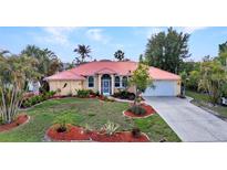 Charming single-Gathering home with a red roof, well-kept lawn, and tropical landscaping at 3058 Curry Ter, Port Charlotte, FL 33981