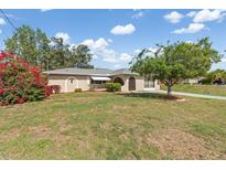 Charming single-story home featuring arched doorways and a well-maintained front yard with mature landscaping at 485 Dorchester St, Port Charlotte, FL 33954