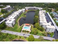 Scenic aerial view of condo community with a pool, lake and mature landscaping at 6070 80Th N St # 215, St Petersburg, FL 33709