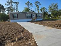 Charming home featuring a long driveway and well-manicured lawn at 15431 Orangeade Dr, Punta Gorda, FL 33955