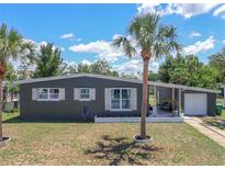 Charming single-story home featuring a well-maintained yard, white trim, and complemented by a mature palm tree at 2142 Gerard Ct, Port Charlotte, FL 33952