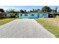 Charming single-story home featuring a light blue exterior with well-maintained landscaping at 23476 Harper Ave, Punta Gorda, FL 33980