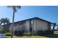 This is an exterior view of the multi-Gathering residence with well-maintained landscaping and a clear blue sky at 4056 Oakview Dr # E10, Port Charlotte, FL 33980