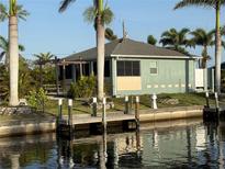 Charming waterfront home featuring a private dock and lush tropical landscaping at 4231 Hollis Ave, Port Charlotte, FL 33953