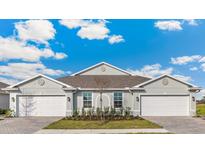Charming home featuring a well manicured lawn, a lovely tree, and two-car garages at 4911 Schubert Trl, North Port, FL 34287