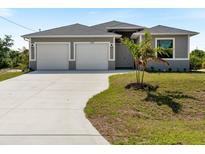 Charming single-story home featuring a well-manicured lawn, a spacious two-car garage, and a welcoming front entrance at 7149 Sea Mist Dr, Port Charlotte, FL 33981