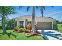 Charming single-story home featuring a well-manicured lawn, tropical landscaping, and a two-car garage at 7505 Carissa, Punta Gorda, FL 33955