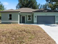 Charming one-story home with a grey door, gray two-car garage, and newly installed driveway at 8849 Attalla Ave, North Port, FL 34287