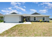 Charming single-story home featuring a two-car garage, well-manicured lawn, and a welcoming front entrance at 16031 Hesta Misty Ct, Punta Gorda, FL 33955