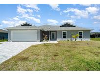 Charming single-story home with a well-manicured lawn, gray siding, and a two-car garage at 16098 Overdale Ct, Punta Gorda, FL 33955
