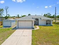 Charming single-story home with a well-maintained lawn, two car garage, and a separate storage shed at 1981 Arena Ln, North Port, FL 34286