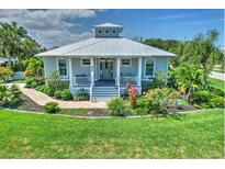 Charming single-story home with metal roof, inviting front porch, walkway, and beautifully landscaped front yard at 329 W Grace St, Punta Gorda, FL 33950