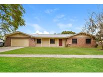 Charming single-story home featuring a metal roof, stone accents, and a well-maintained front yard at 406 Merlin Ct, Brandon, FL 33510