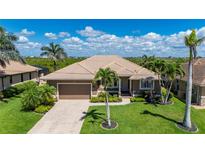 Beautiful single-story home with a well-manicured lawn, mature palm trees, and a two-car garage at 695 Macedonia Dr, Punta Gorda, FL 33950