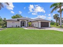 Charming home with lush lawn, freshly mulched planting beds, and a dark-colored two-car garage at 7448 S Blue Sage, Punta Gorda, FL 33955