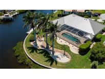 Aerial view of a screened-in pool and lush landscaping in a waterfront backyard at 1435 Pine Island Ct, Punta Gorda, FL 33950