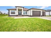 Stunning single-story home featuring a three-car garage and well-kept lawn at 15 Tournament Rd, Rotonda West, FL 33947