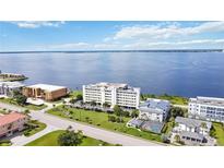 Expansive aerial view of a condo building on a scenic coastline with lush landscaping at 1500 Park Beach Cir # 2F, Punta Gorda, FL 33950