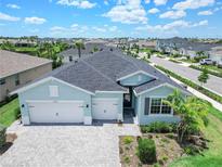 Inviting one-story home showcasing a neatly landscaped yard, brick paver driveway, and a two-car garage at 17629 Palmetto Pass Ln, Punta Gorda, FL 33982