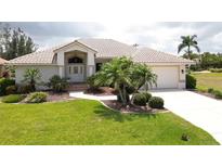 Charming single-story home featuring a well-manicured lawn, lush landscaping, and a neutral-colored tile roof at 3518 Terin Ct, Punta Gorda, FL 33950