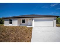 Newly built single-story home with a white exterior, garage, and a neatly laid driveway under a clear blue sky at 359 Salisbury St, Port Charlotte, FL 33954