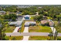 An aerial view of single-Gathering homes boasting well-maintained lawns and mature trees enhancing curb appeal at 3886 Cincinnati St, North Port, FL 34286