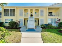 Charming two-story condo building with a well-maintained lawn and inviting stairway at 410 Cerromar S Cir # 240, Venice, FL 34293