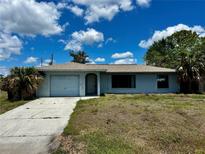 Charming single-story home with a well-manicured lawn and a classic architectural design and a driveway at 5498 Montego Ln, Port Charlotte, FL 33981