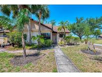 Charming home exterior with lush tropical landscaping and mature trees in a sunny setting at 5641 Mashie Cir, North Port, FL 34287