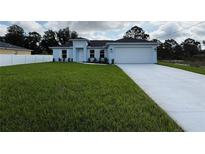 Charming single-story home featuring a two-car garage and well-manicured lawn at 6274 Skyview Dr, North Port, FL 34291