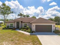 Charming home with lush landscaping, well-manicured lawn and a two-car garage at 16094 Ortega Dr, Punta Gorda, FL 33955