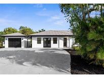 Charming home with a metal roof, freshly painted white exterior, and a detached garage at 19723 Midway Blvd, Port Charlotte, FL 33948