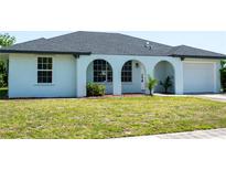 Beautiful single-story home featuring a well-manicured lawn and an attached one car garage at 2271 Alton Rd, Port Charlotte, FL 33952