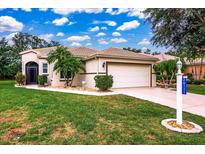 Charming single-story home featuring a tile roof, two-car garage, and well-maintained landscaping at 26111 Feathersound Dr, Punta Gorda, FL 33955