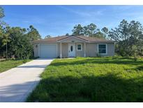 Charming single-story home with a well-manicured lawn and a concrete driveway at 27128 Aloha Dr, Punta Gorda, FL 33955