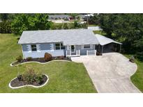 Charming single-story home with a manicured lawn, quaint carport, and inviting front porch at 2805 Gussie St, Punta Gorda, FL 33950