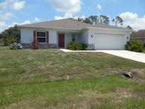 Charming single-story home with a well-maintained lawn, stone accents, and a two-car garage at 4830 Cazes Ave, North Port, FL 34287