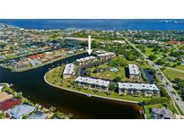 Stunning aerial view of waterfront condos with boat docks and a community pool nestled along a scenic canal at 601 Shreve St # 21C, Punta Gorda, FL 33950