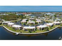 Beautiful aerial view of a waterfront condo complex with a community pool and surrounding landscaping at 1080 Bal Harbor Blvd # 12C, Punta Gorda, FL 33950