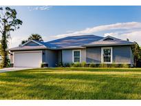 Charming single-story home featuring a well-manicured lawn and attached two-car garage at 16280 Minorca Dr, Punta Gorda, FL 33955