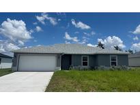 Charming single-story home features a gray exterior, well-maintained lawn, and an attached two-car garage at 16280 Minorca Dr, Punta Gorda, FL 33955
