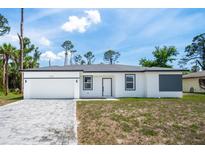 Charming single-story home featuring a gray brick driveway and a freshly painted white exterior at 17197 Russell Ave, Port Charlotte, FL 33954