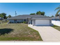 Charming single story home featuring a well-maintained yard, attached two-car garage, and neutral paint scheme at 19468 Edgewater Dr, Port Charlotte, FL 33948